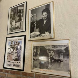 Framed classic Italian film photos decorating the wall of Shazanna pizzeria.