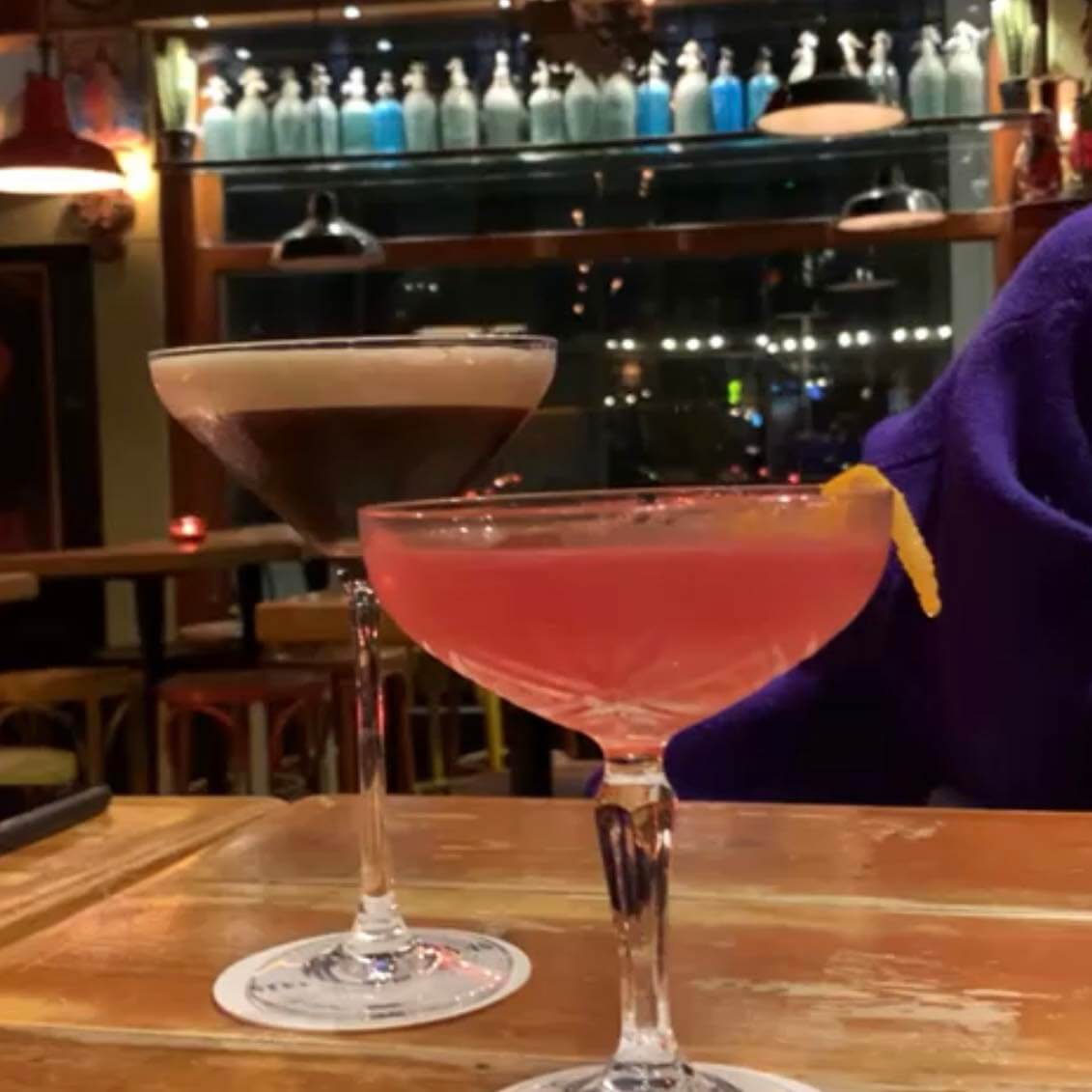 two cocktail glasses in a bar