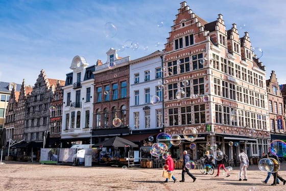 Ghent-Soap-bubbles-flying-over-the-Korenmarkt-square-on-a-sunny-day-in-the-medieval-city-center-of-Ghent.-Province-of-East-Flanders