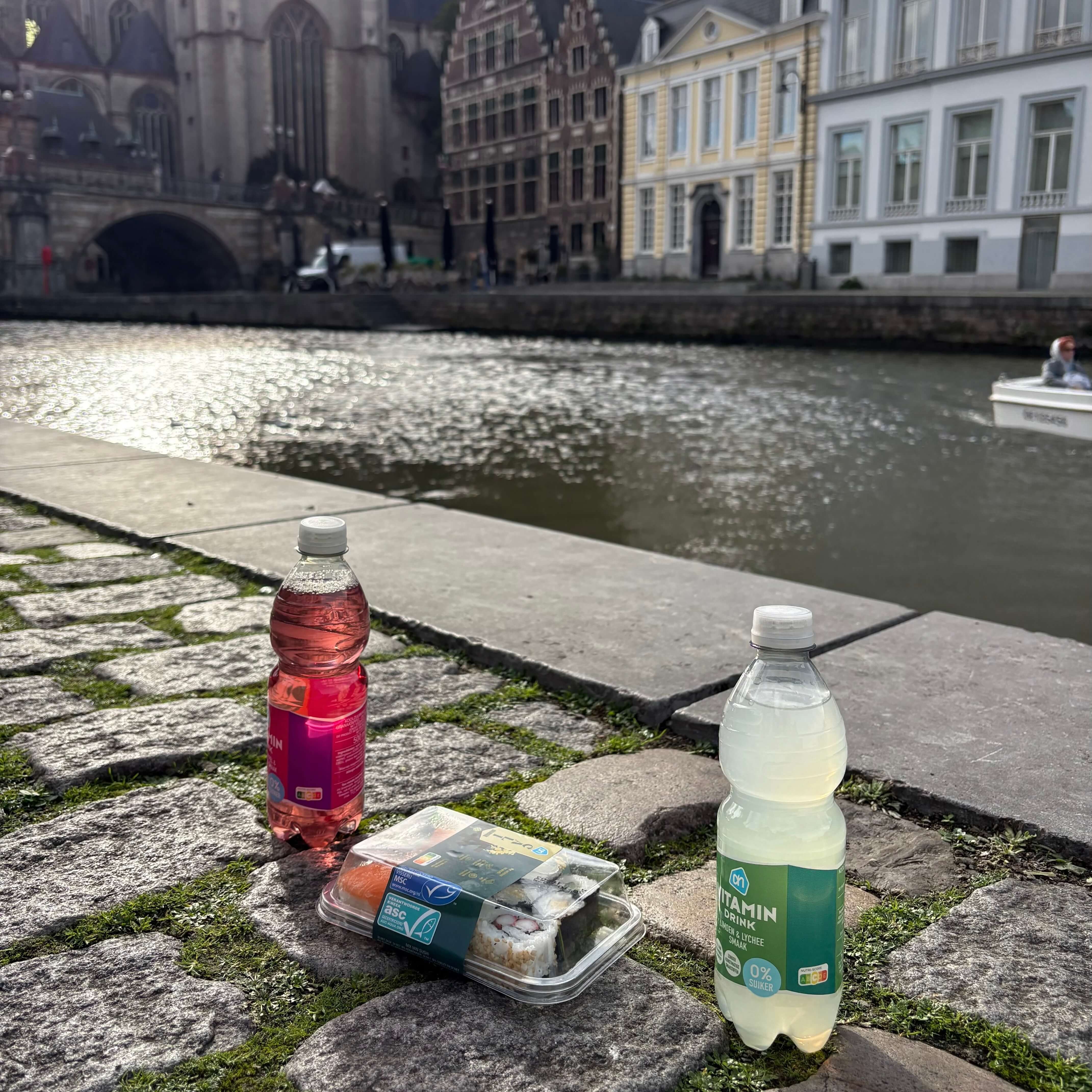 Picnic food infront of Graslei’s historic buildings along the river in the sunshine.