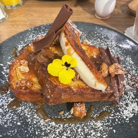 Brioche french toast with fresh banana's, butterscotch caramel, candied peanuts and chocolate flakes