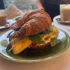 Croissant with scrambled eggs, avocado and labneh