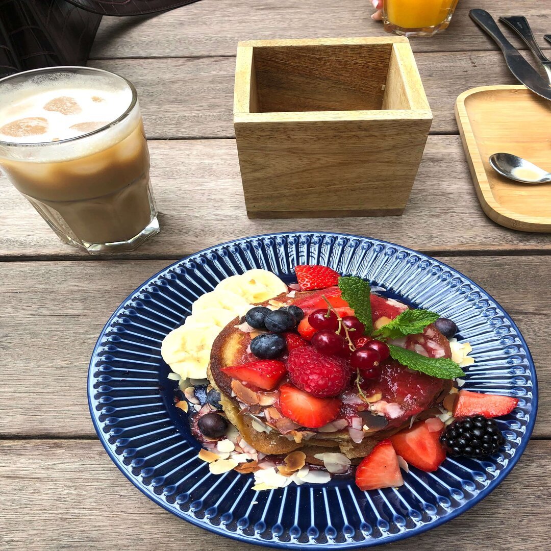 Pancakes with strawberries, almond flakes and maple syrup at Stek 