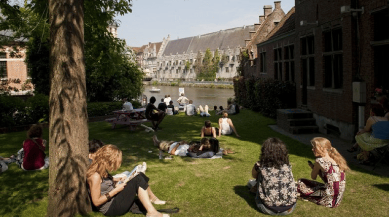 People sitting on the grass next to the canal at Appelbrugparkje