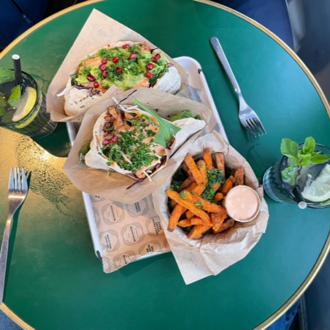 Two mouthwatering pitas, perfectly filled with a variety of succulent ingredients. Next to them, two refreshing homemade lemonades add a splash of color. Completing the ensemble are a generous serving of crispy sweet potato fries, golden and ready to be enjoyed