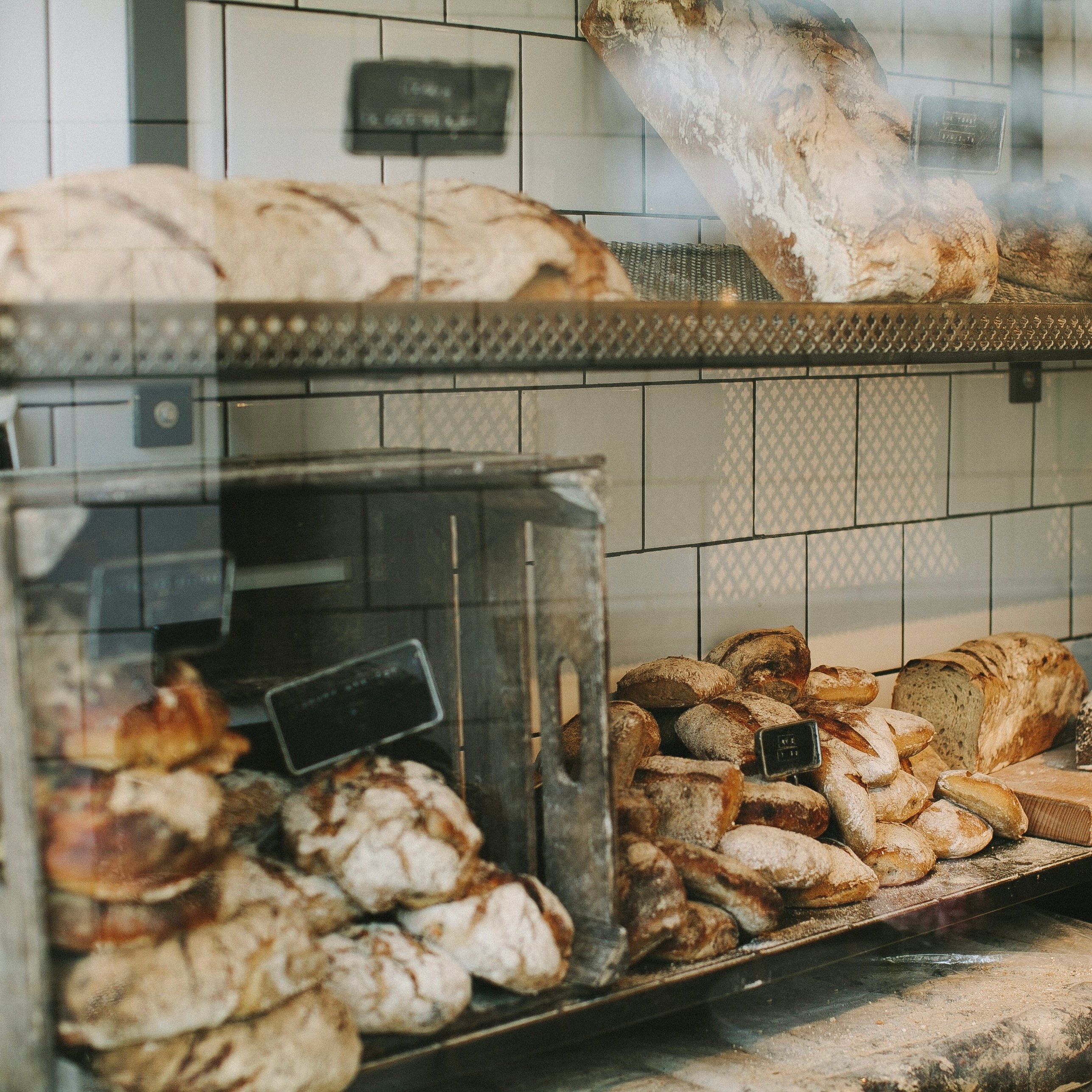 photo of a stock of bread laid out in bulk on the shelves of a bakery