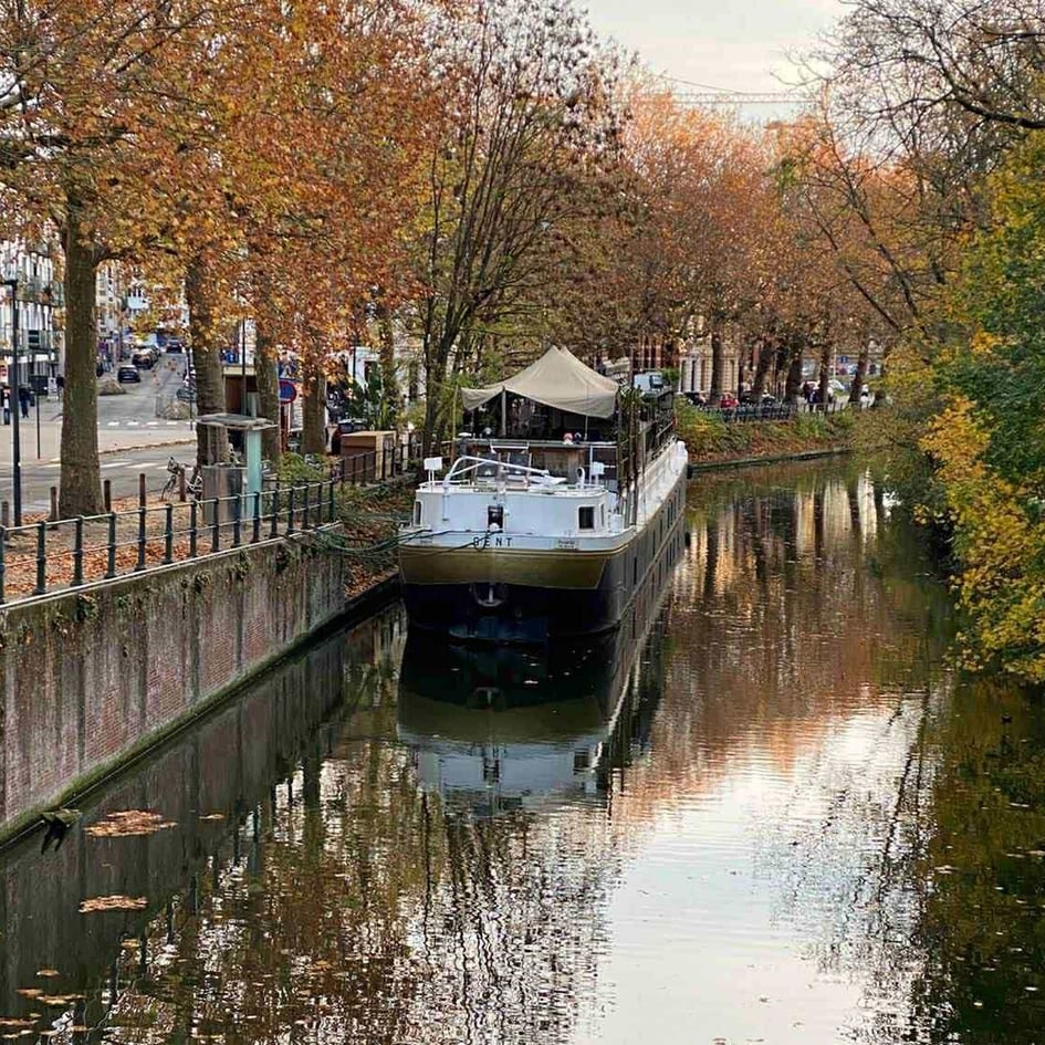 View of the Kaffee de Planck boat from the bridge, showing its sleek design on the water.