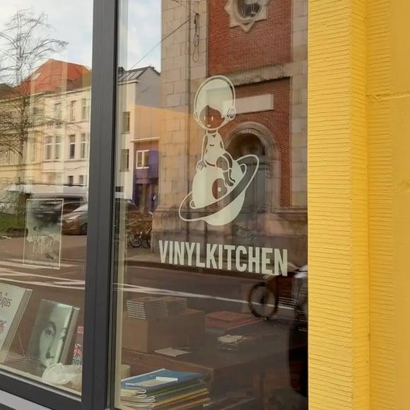 Window with logo with a girl with headphones witting on a planet. Books in the display