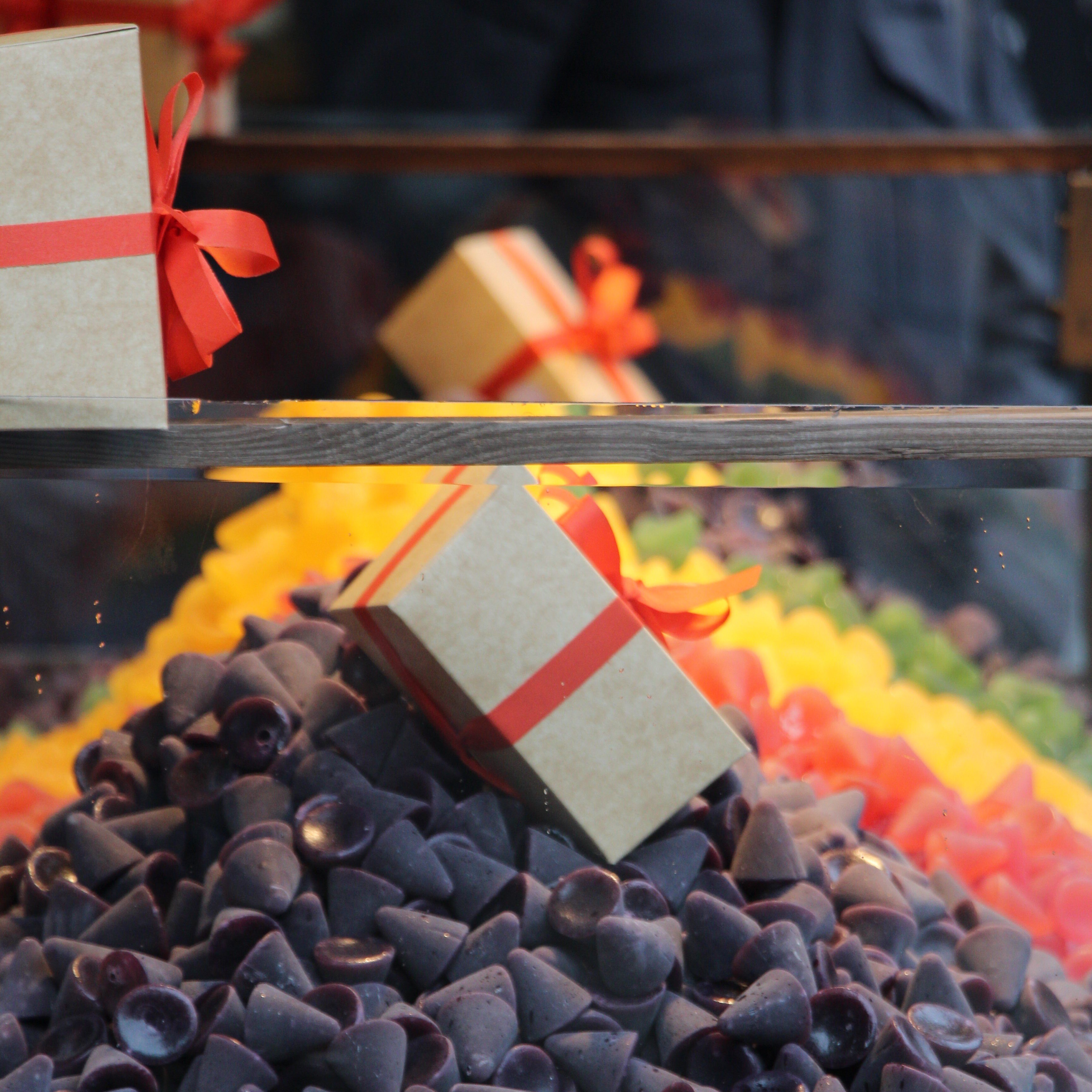 Close-up of traditional purple cuberdons (cone-shaped Belgian sweets) stacked at a market stall in Ghent.