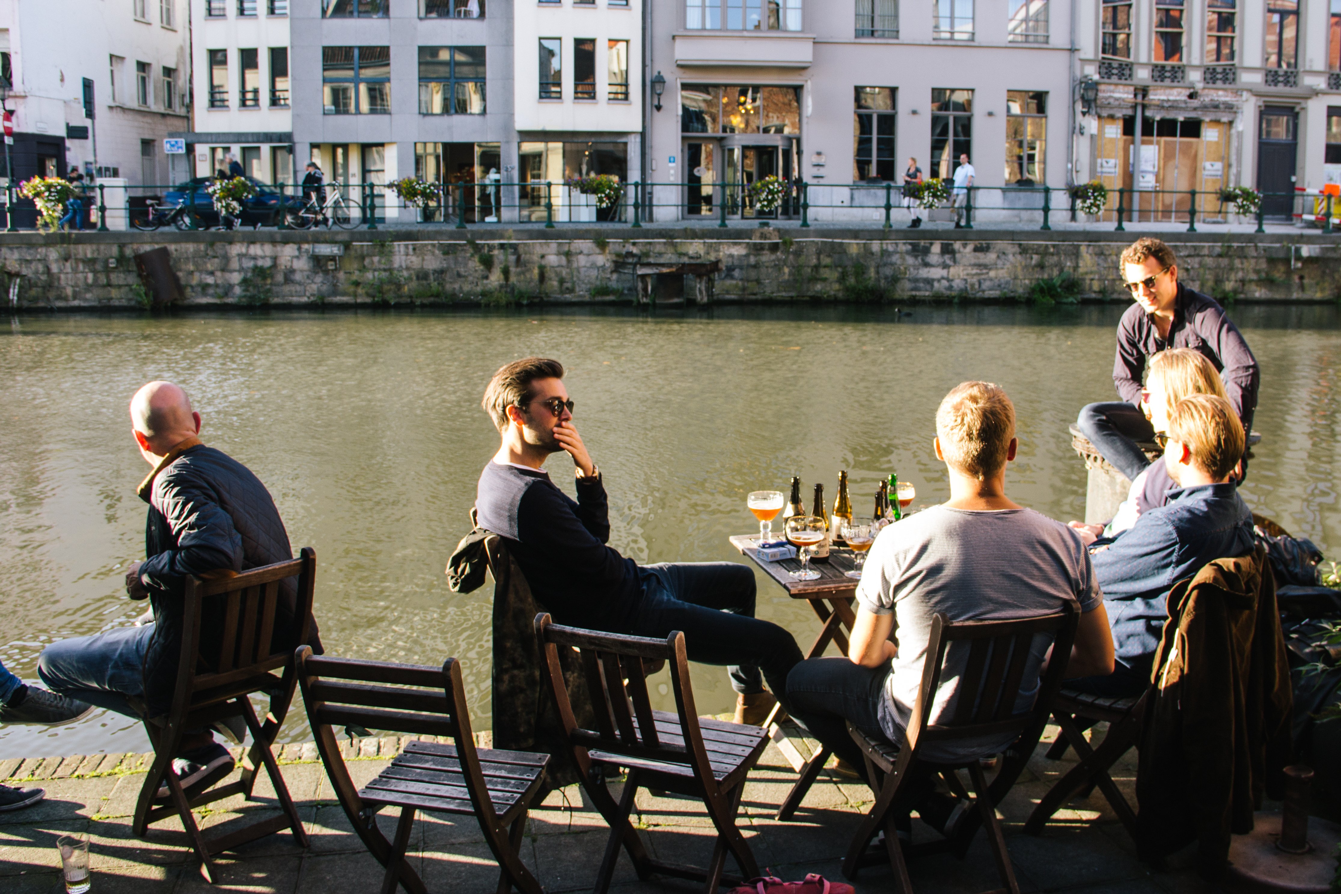 People enjoying a drink and the view of the Lys river