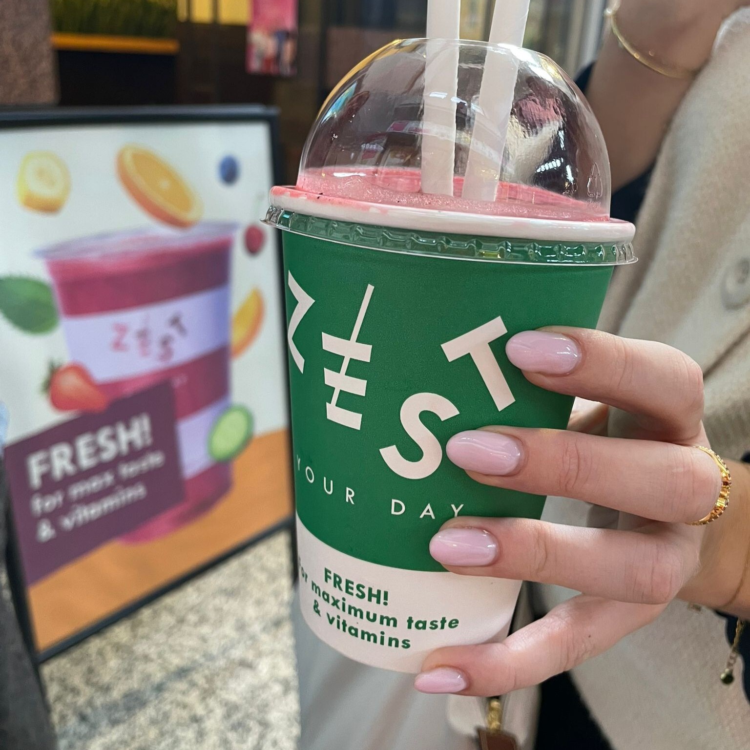 Someone holding a cup with the ZEST juice