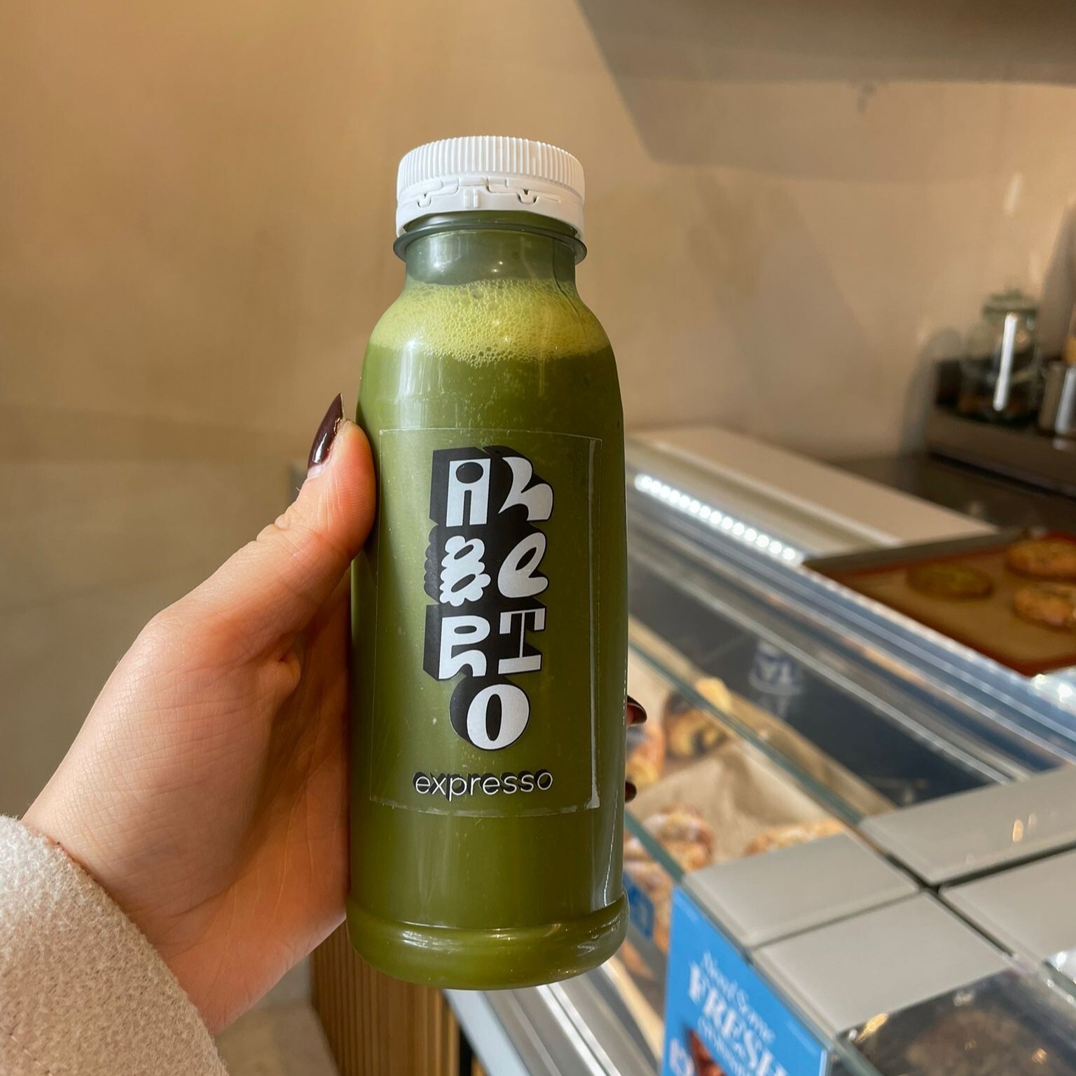 Someone holding the bottle with the fresh juice from Alberto Expresso