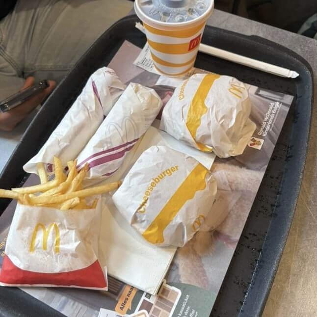 a photo of two burgers, fries, a soft drink, and two chicken wraps from McDonald's